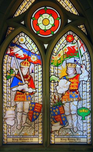 Stained glass window depicting Kings Richard III and Henry VII, showcasing historical significance related to the Battle of Bosworth Field.